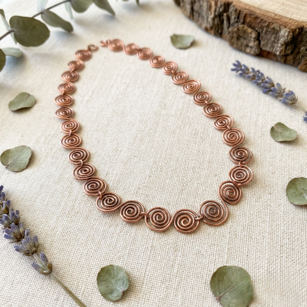 Celtic Copper necklace on a textured surface with leaves and lavender flowers