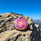 Colorful pendant on a rocky surface with a mountainous background