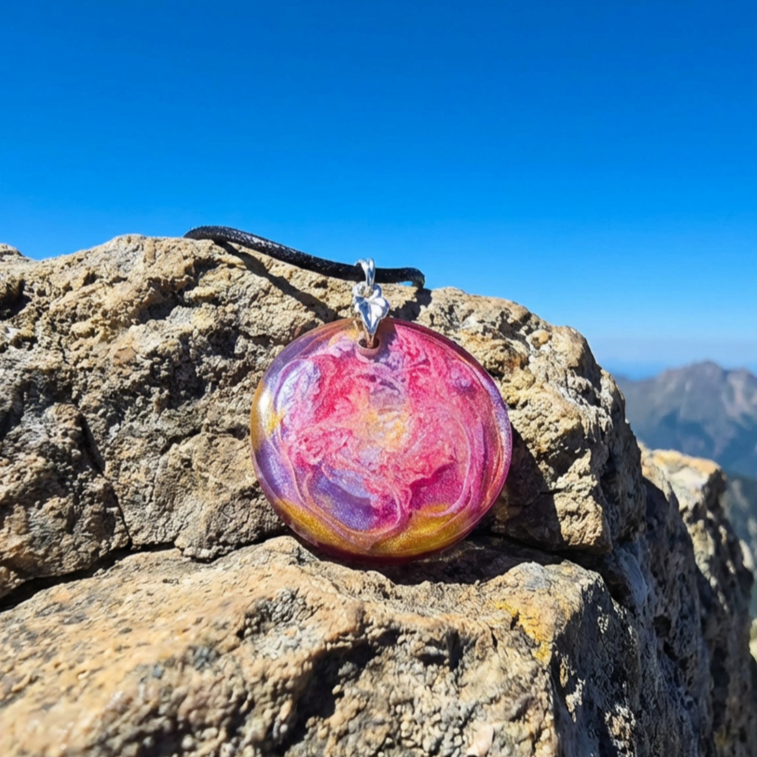 Colorful pendant on a rocky surface with a mountainous background