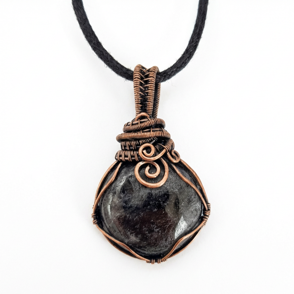 Necklace with a dark stone pendant wrapped in copper wire on a white background