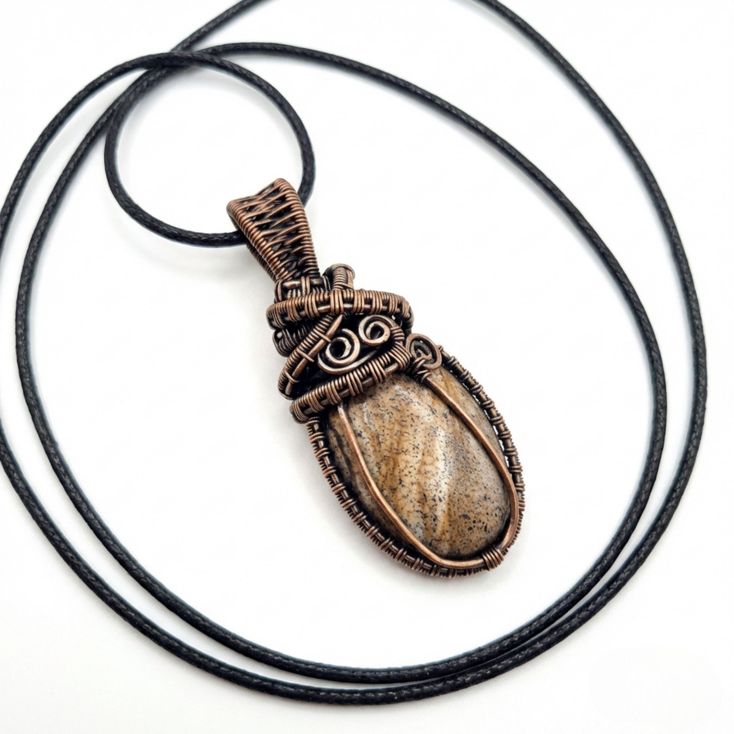 Brown stone pendant on a black cord against a white background