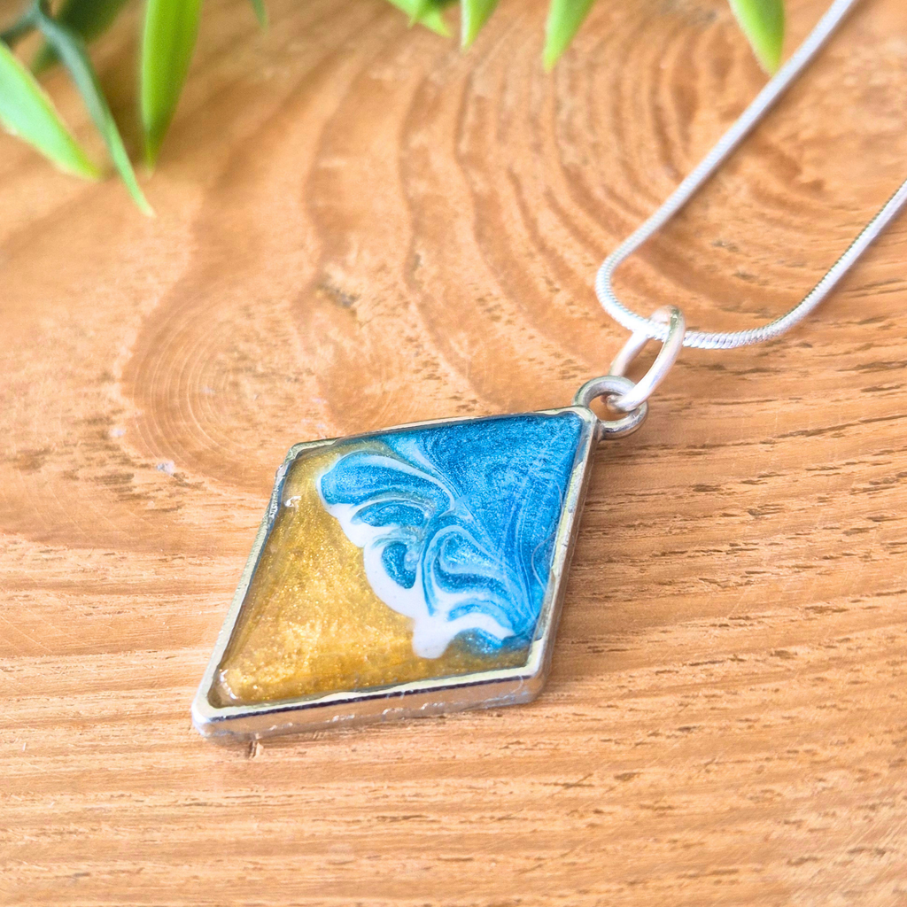 Necklace with a marbled pendant on a wooden surface