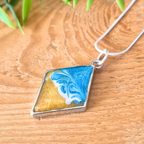 Necklace with a marbled pendant on a wooden surface