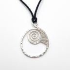Silver spiral pendant on a black cord against a white background