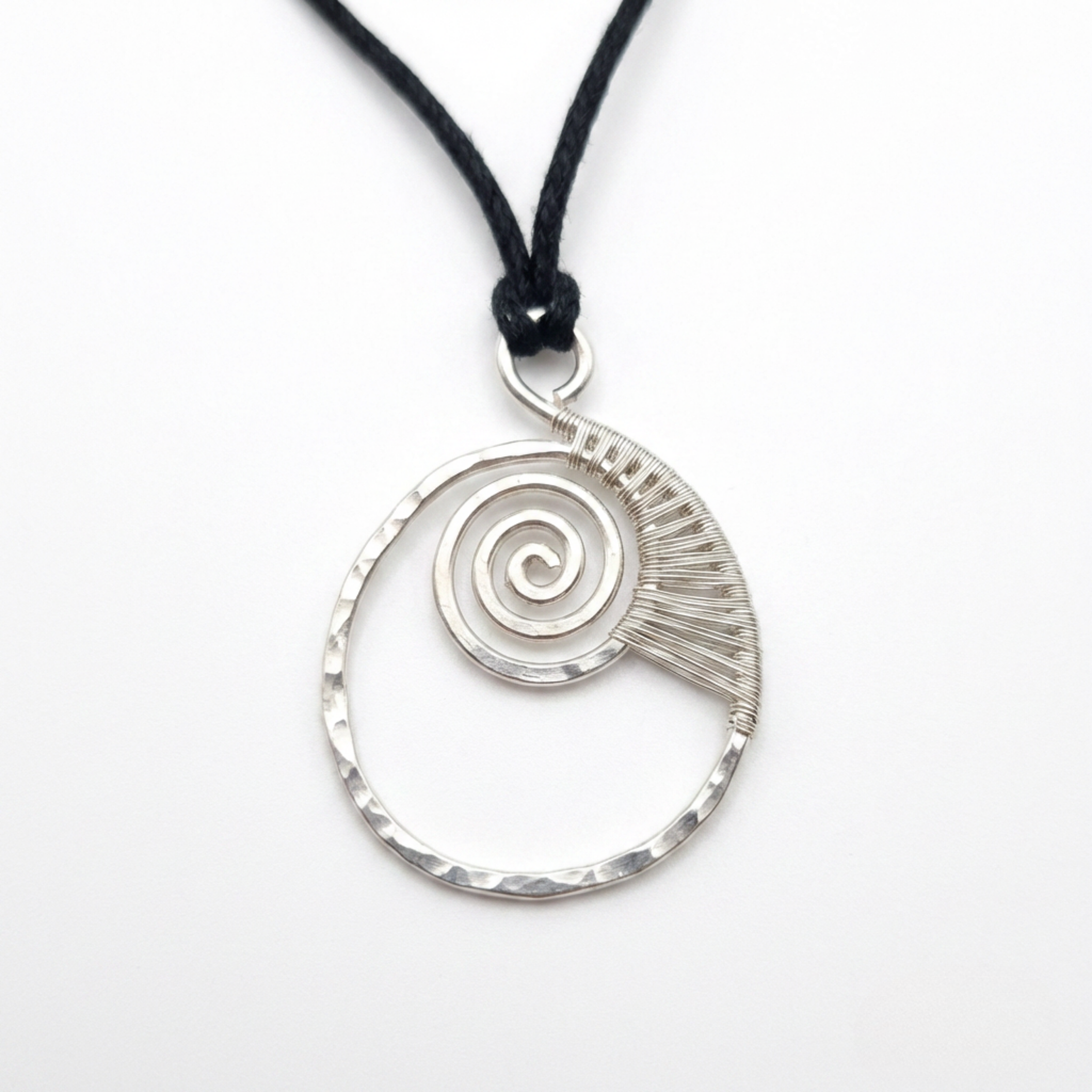 Silver spiral pendant on a black cord against a white background
