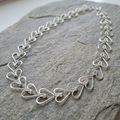 Silver heart-shaped necklace on a stone surface