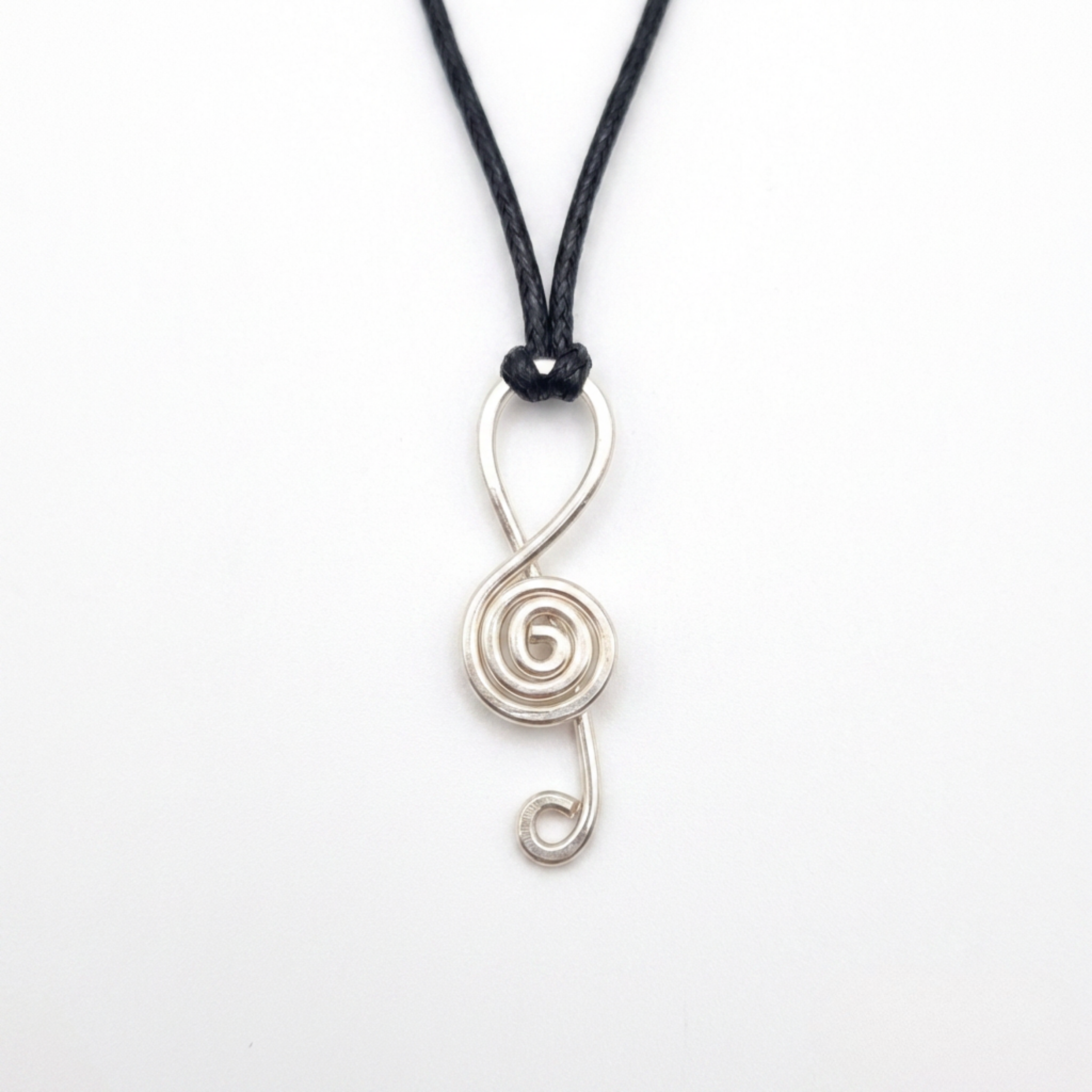 Silver spiral pendant on a black cord against a white background