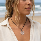 Woman wearing a spiral pendant necklace on a beach