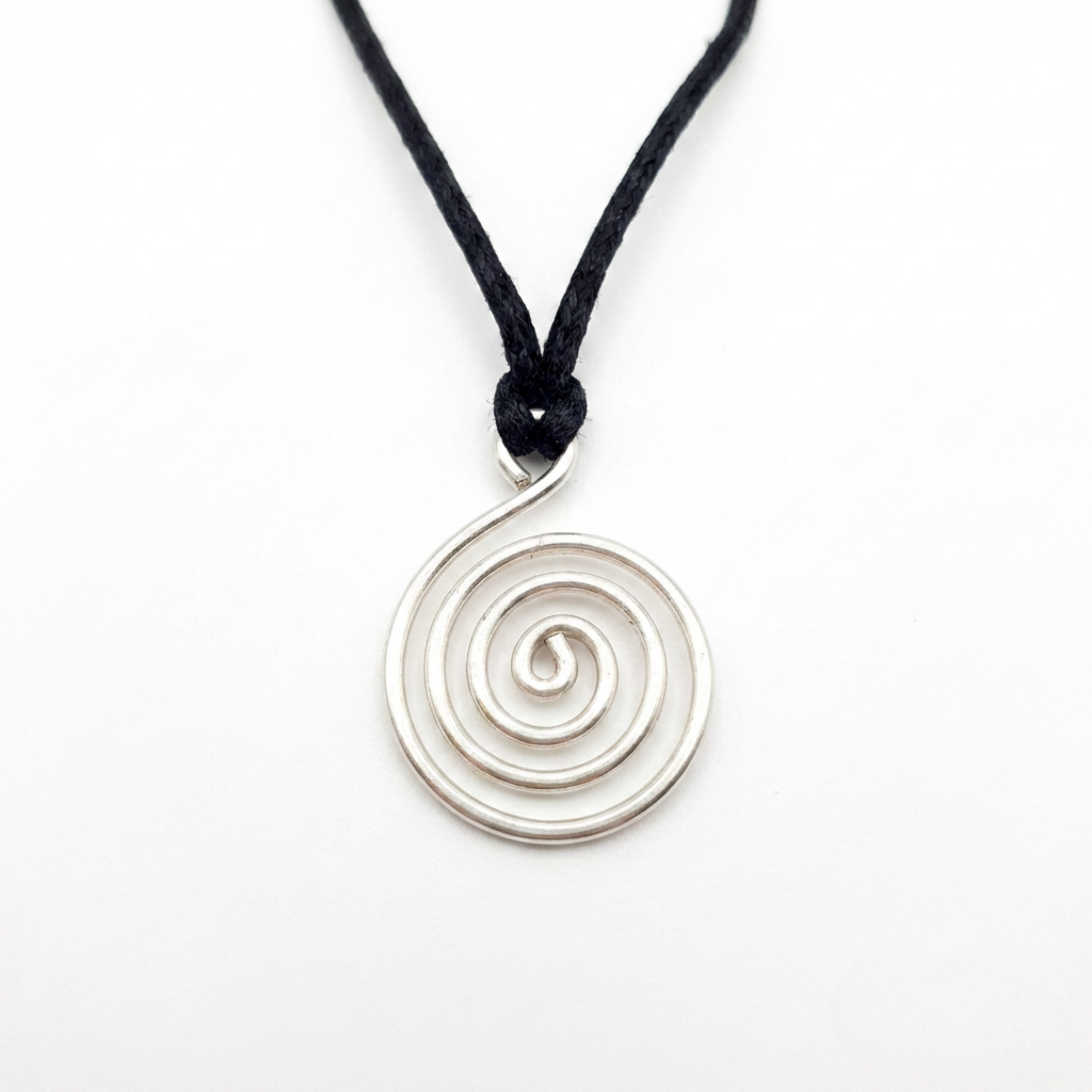 Silver spiral pendant on a black cord against a white background