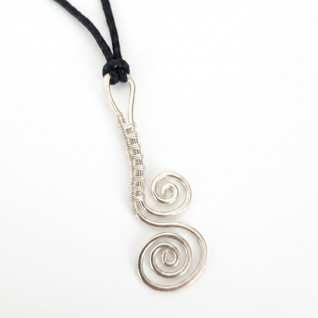 Silver spiral pendant on a black cord against a white background
