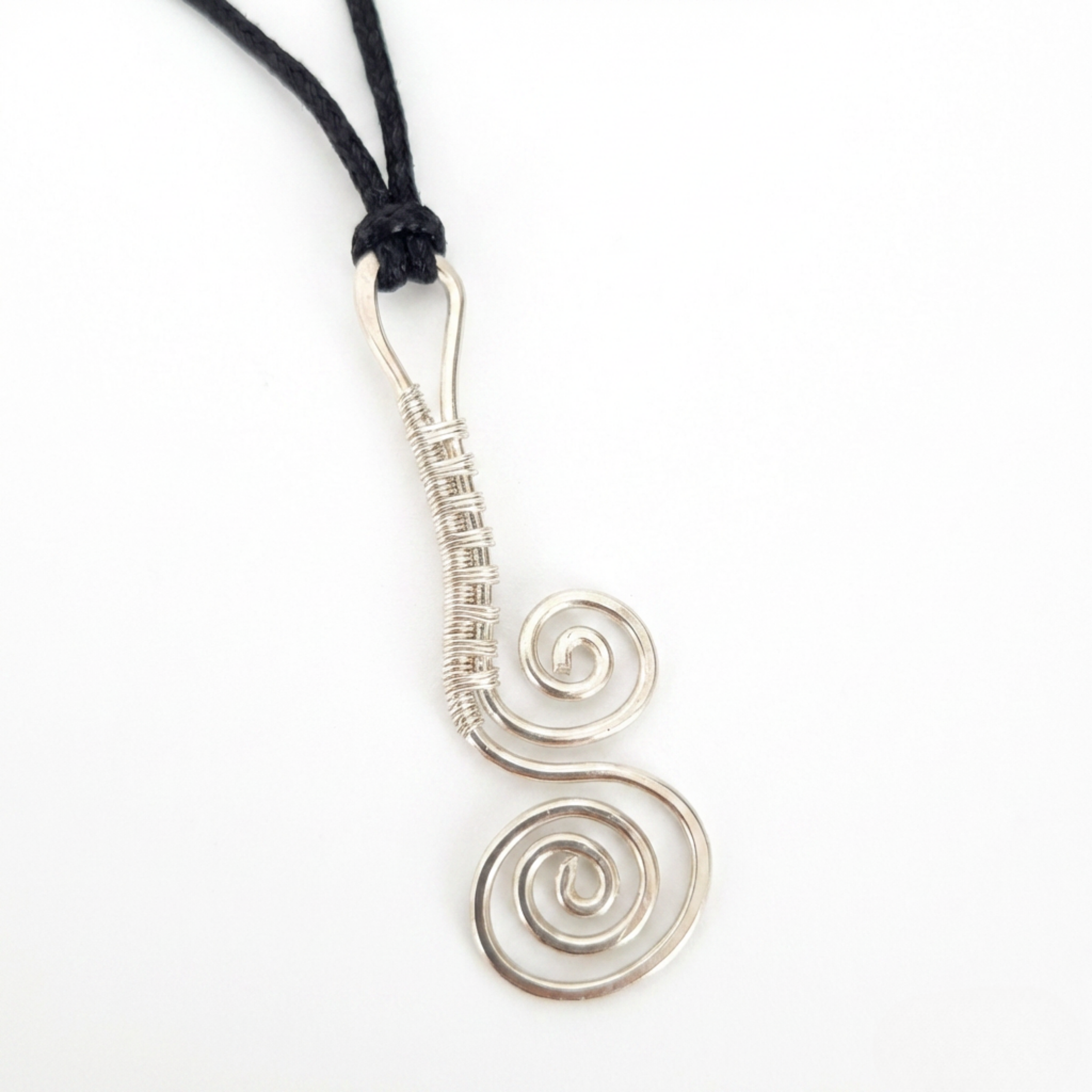 Silver spiral pendant on a black cord against a white background