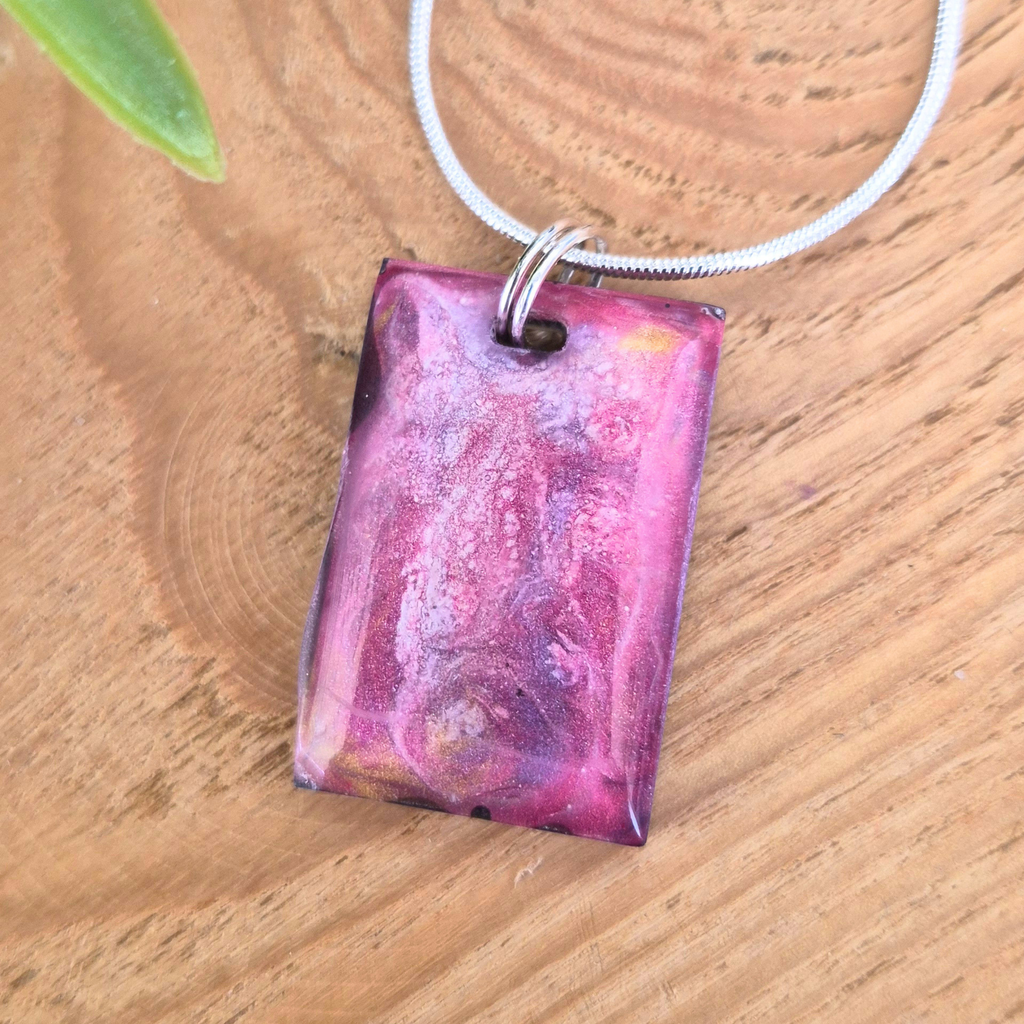 Pink and purple pendant on a wooden surface