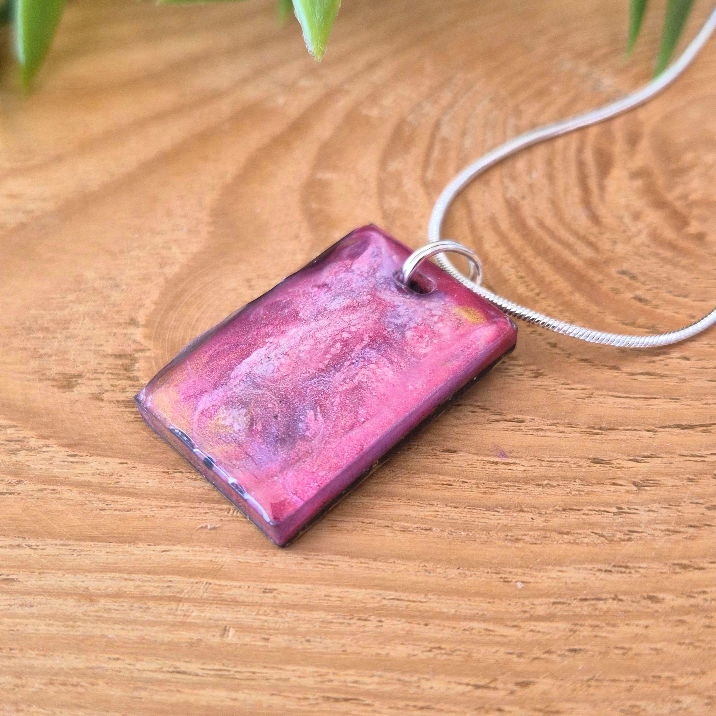Pink rectangular pendant on a wooden surface