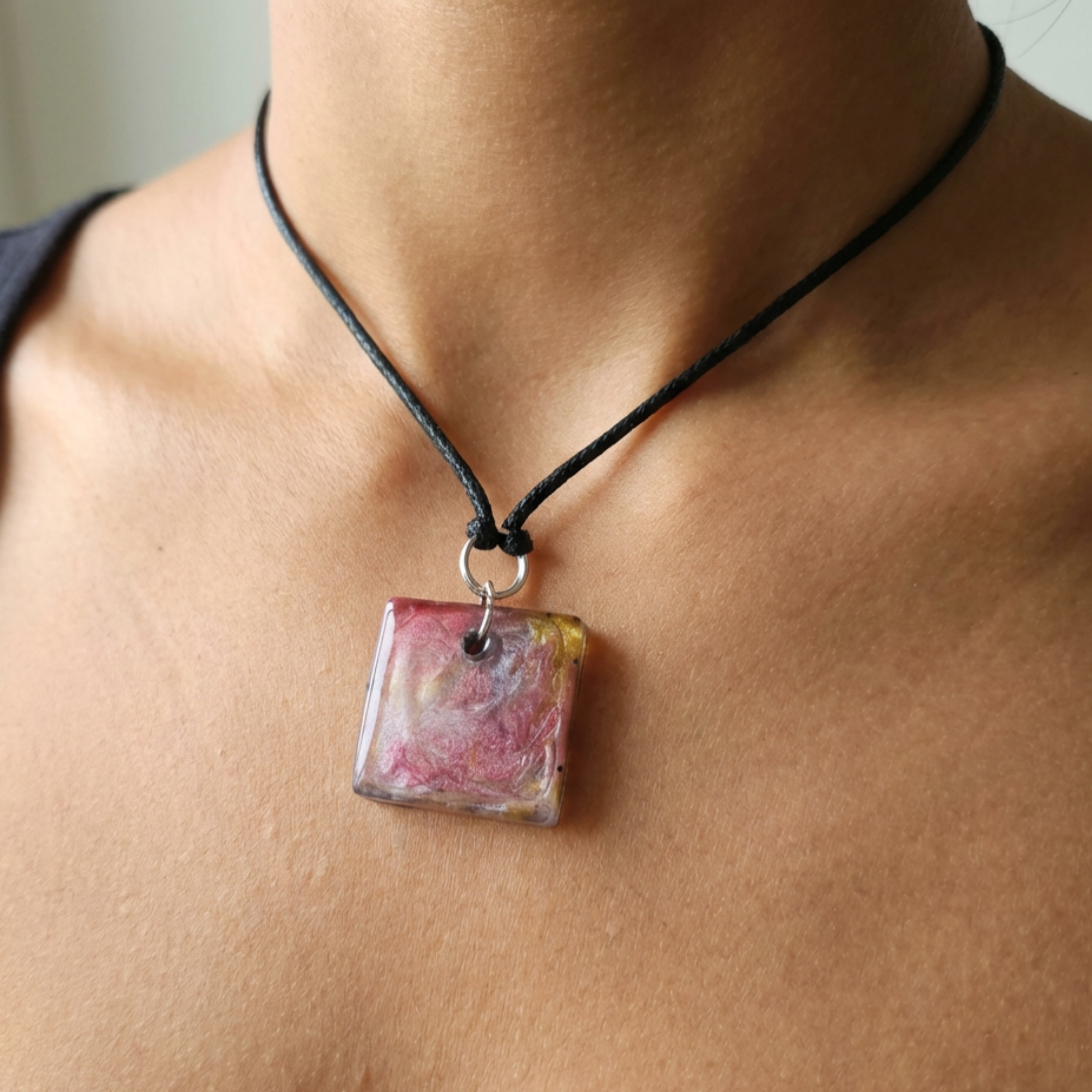 Necklace with a square pendant on a person's neck