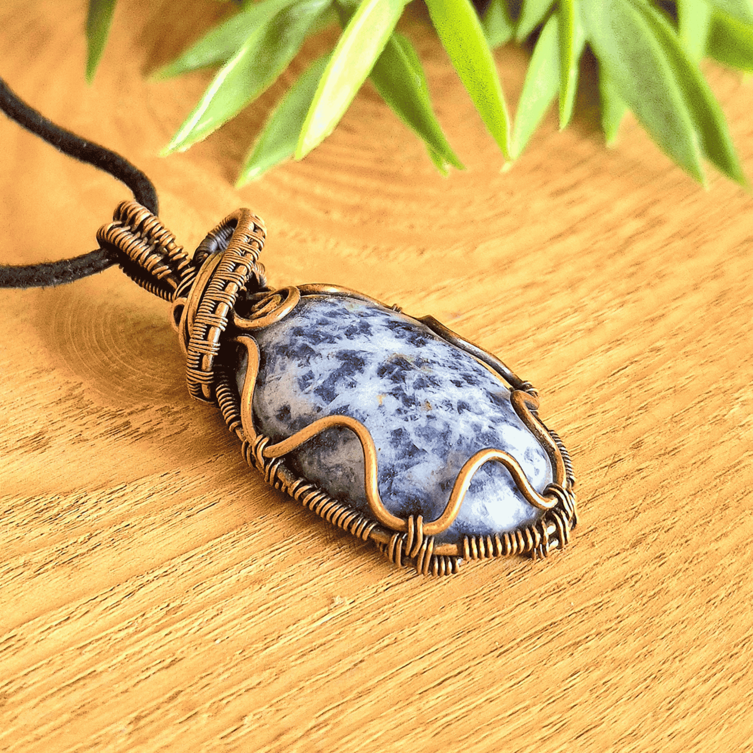 Necklace with a blue stone pendant on a wooden surface