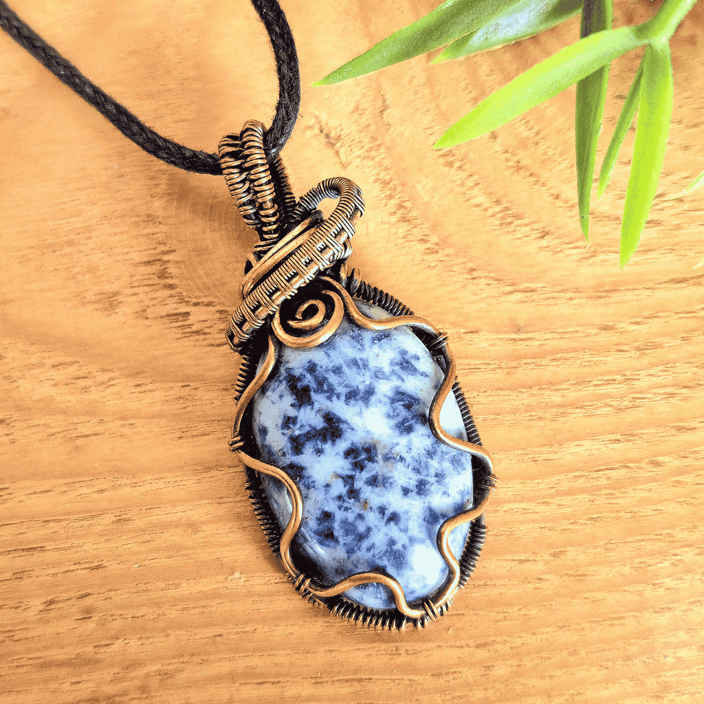 Necklace with a blue stone pendant on a wooden surface