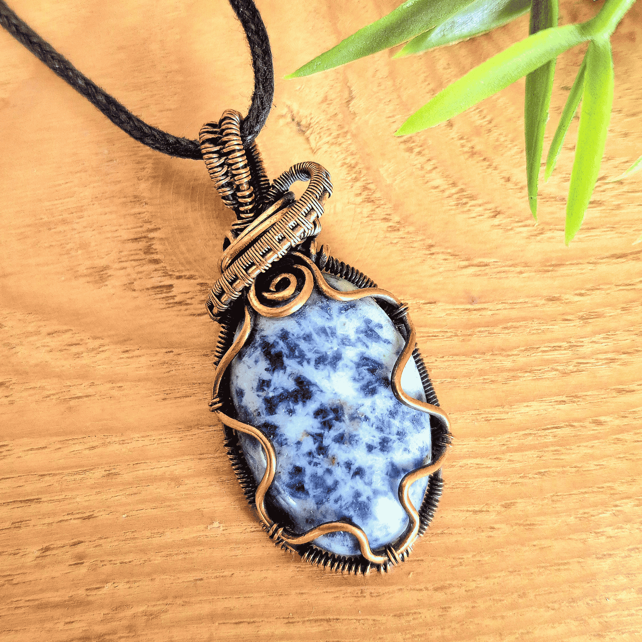 Necklace with a blue stone pendant on a wooden surface