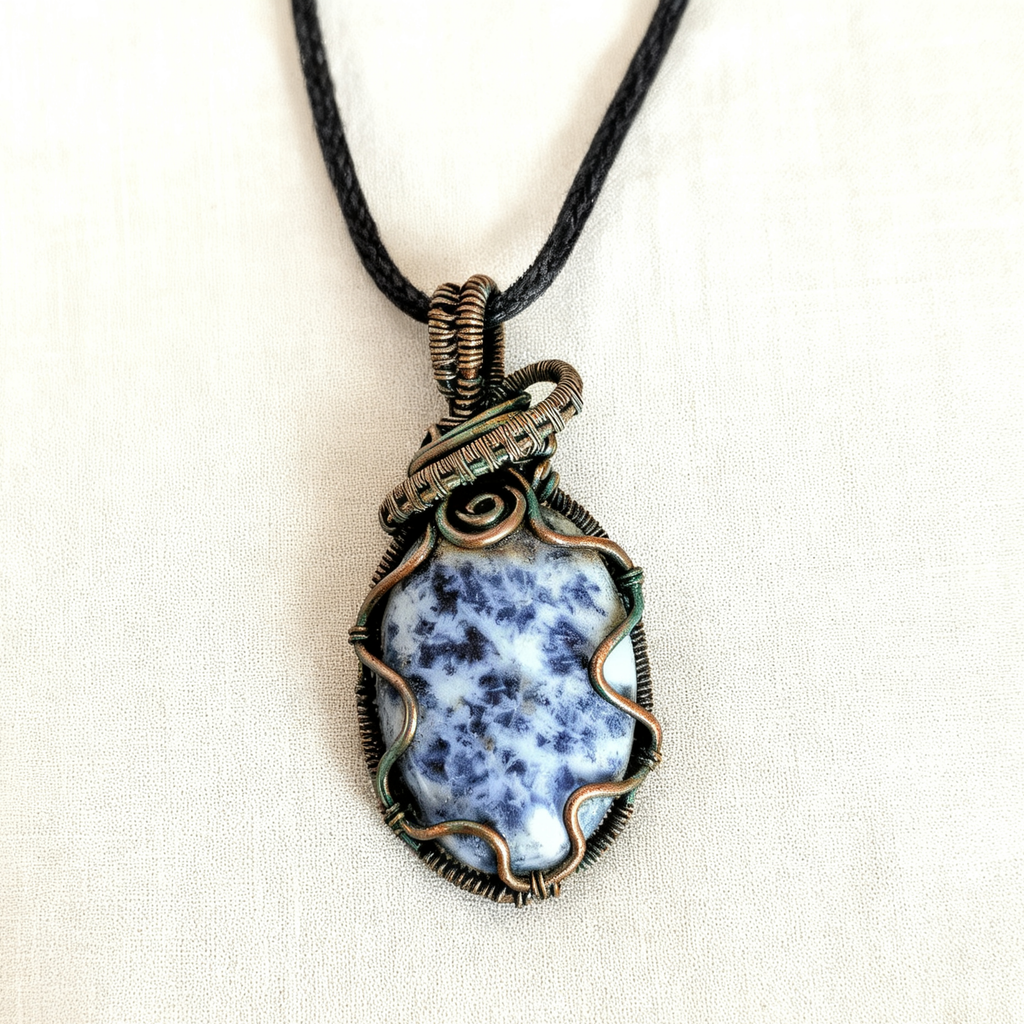 Necklace with a blue dendritic pendant on a white background