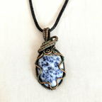 Necklace with a blue dendritic pendant on a white background
