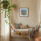 Decorative indoor swing with colourful pillows and a framed artwork on the wall.