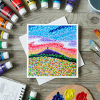 Colourful abstract painting of Glastonbury Tor on a wooden surface with acrylic paint bottles and brushes.