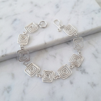 Silver bracelet with geometric design on a marble surface