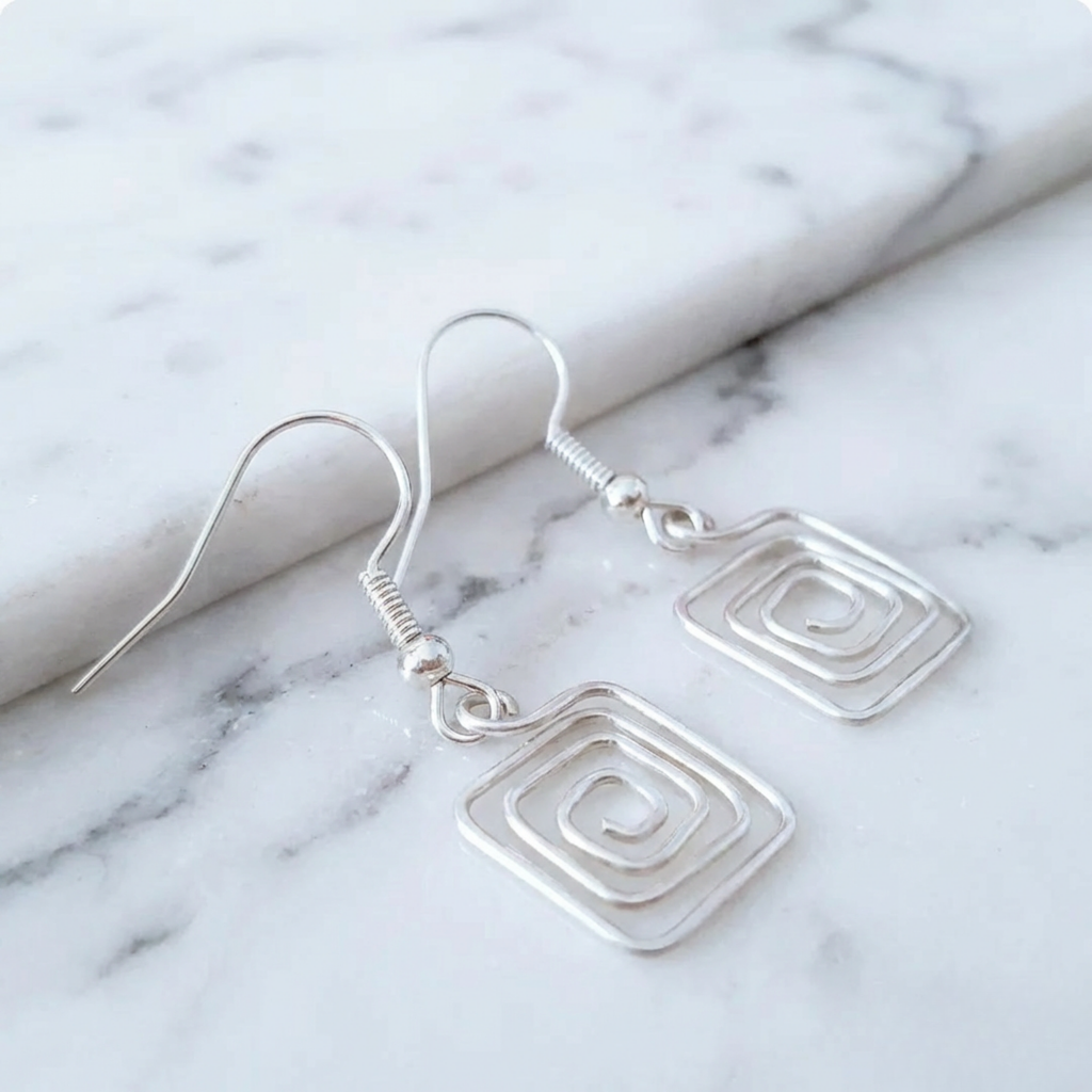 Silver square earrings on a marble surface