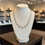 Silver square spiral necklace on a mannequin bust in a jewelry store setting