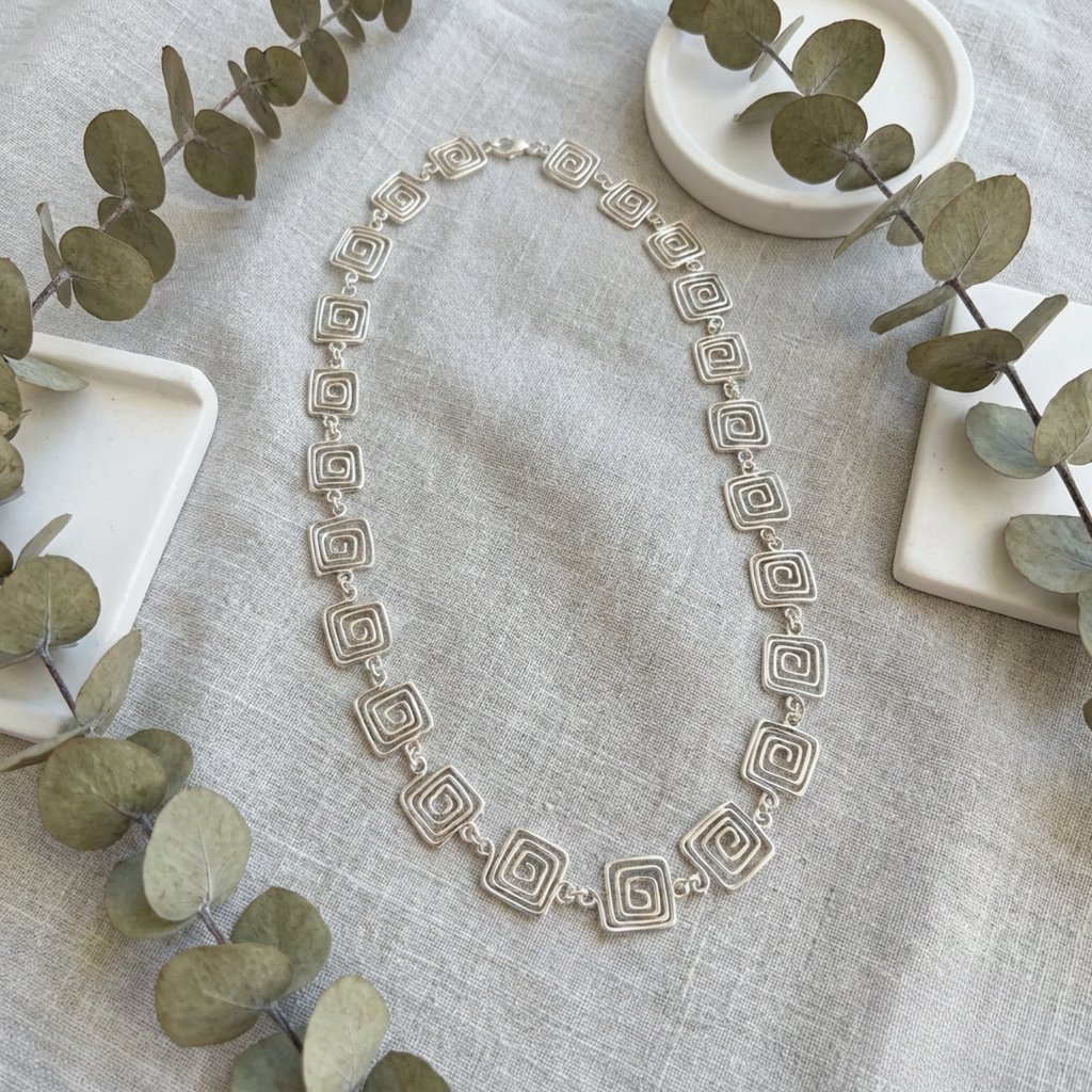 Detailed view of a geometric square Greek style chain necklace in silver