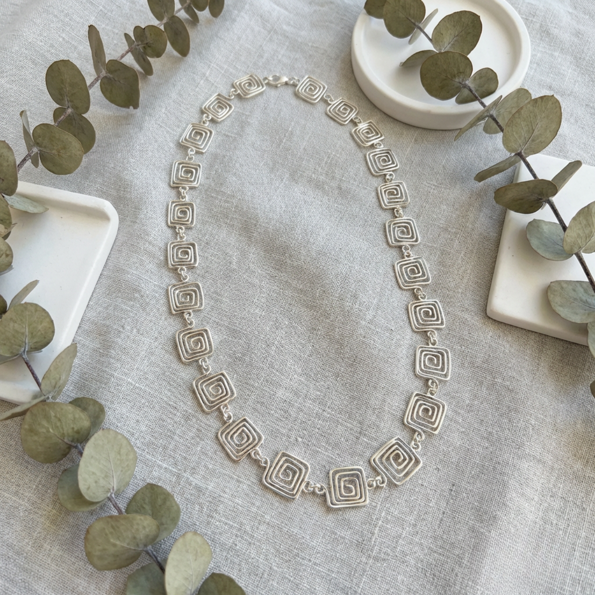 Detailed view of a geometric square Greek style chain necklace in silver