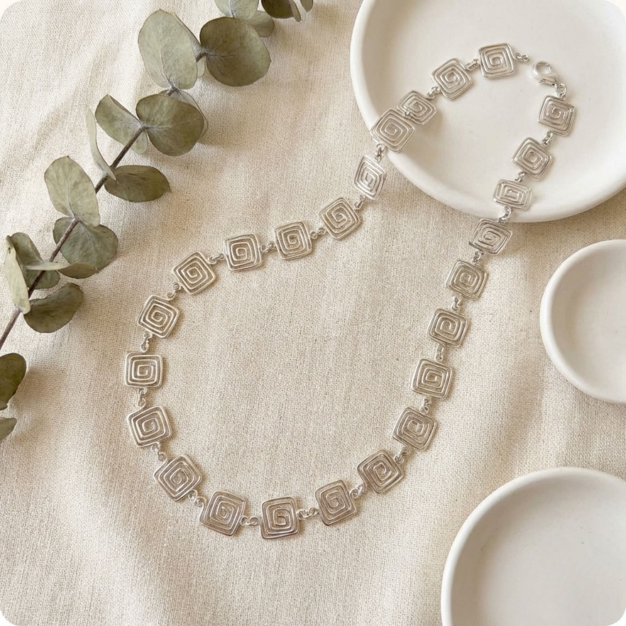 Geometric square spiral chain necklace on a fabric background