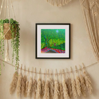 Framed artwork on a wall with decorative elements like pampas grass and macrame.