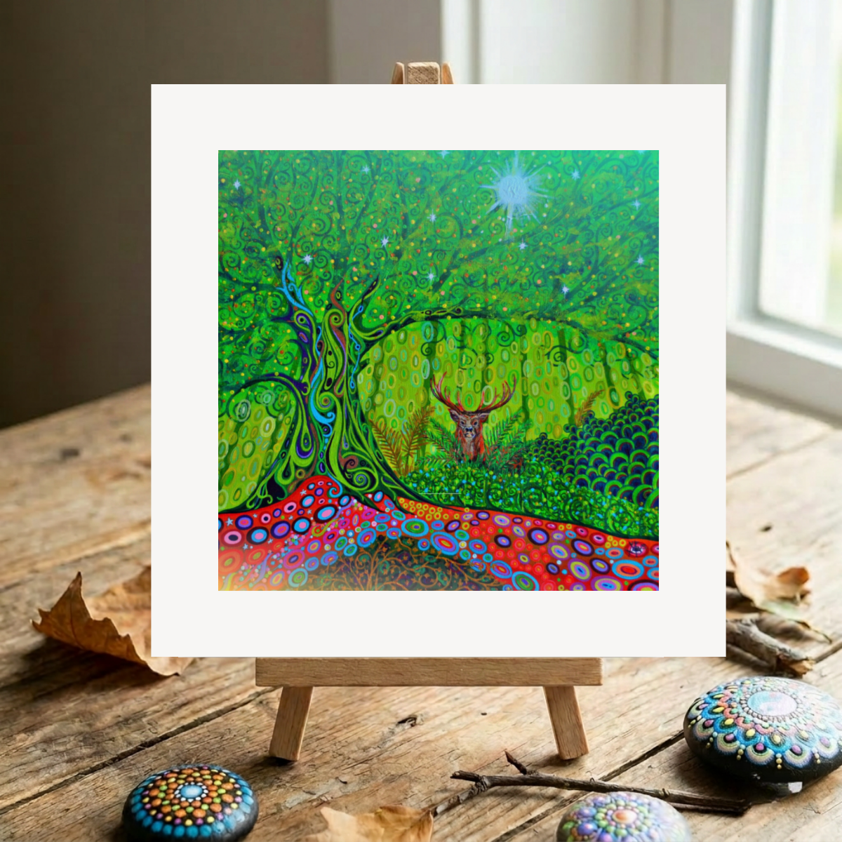 Colourful abstract artwork of a deer in a forest on a wooden easel.