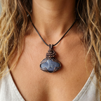 Necklace with a blue pendant worn by a person with blonde hair.