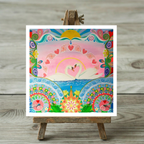 Colourful artwork of swans and decorative elements on a wooden easel.