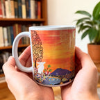 Person holding a colourful mug with artistic design in a home setting