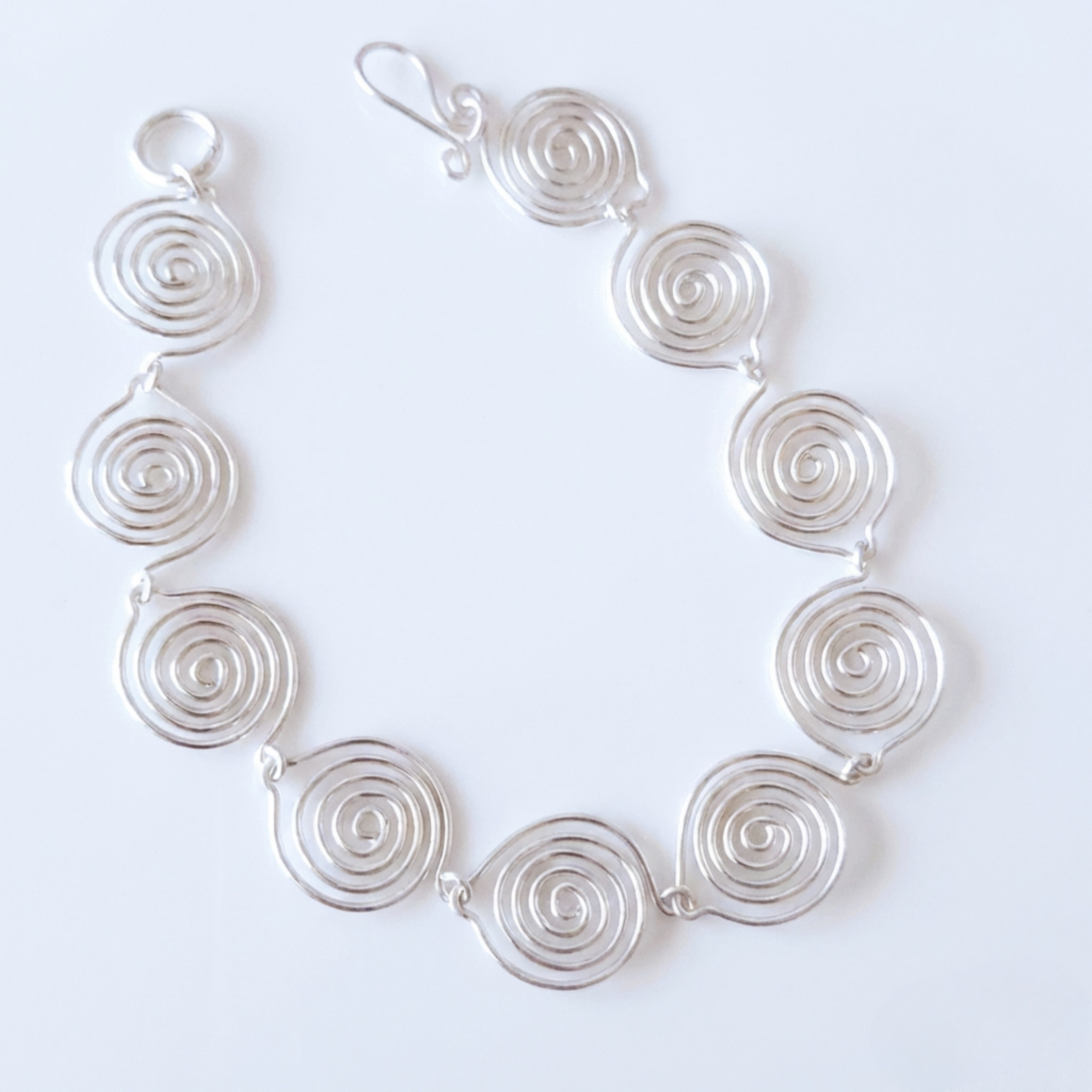 Silver spiral necklace on a white background
