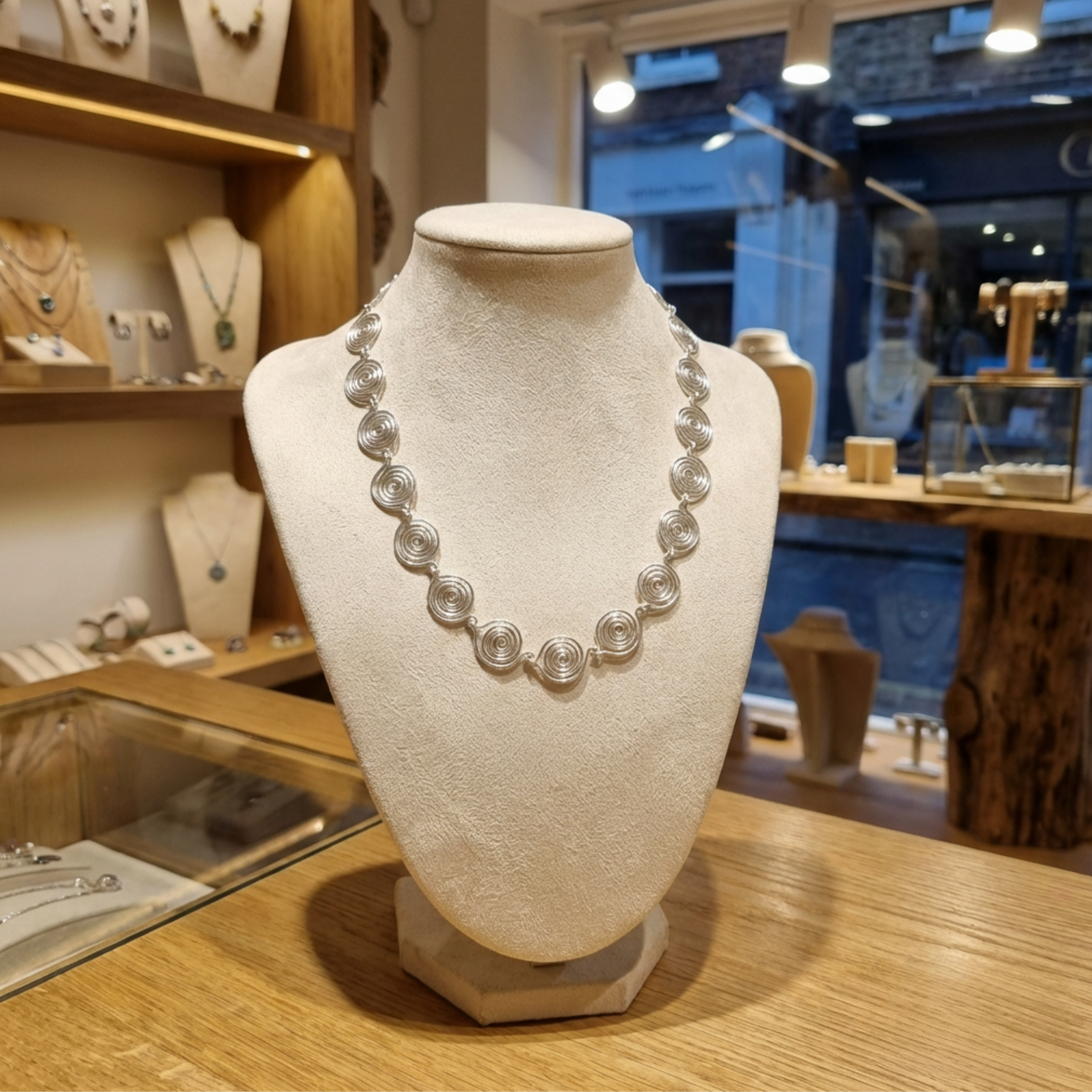 Spiral necklace on a mannequin bust in a jewellery store setting