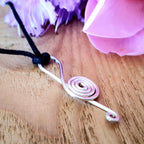 Close-up of a pink and black keychain with a wooden surface background