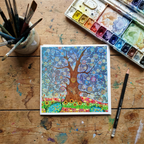 Colourful tree painting on a wooden surface with art supplies