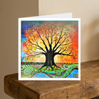 Colourful tree design on a greeting card with a wooden surface and beige background