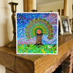 Colourful abstract artwork on a wooden surface with candles and a mirror in the background