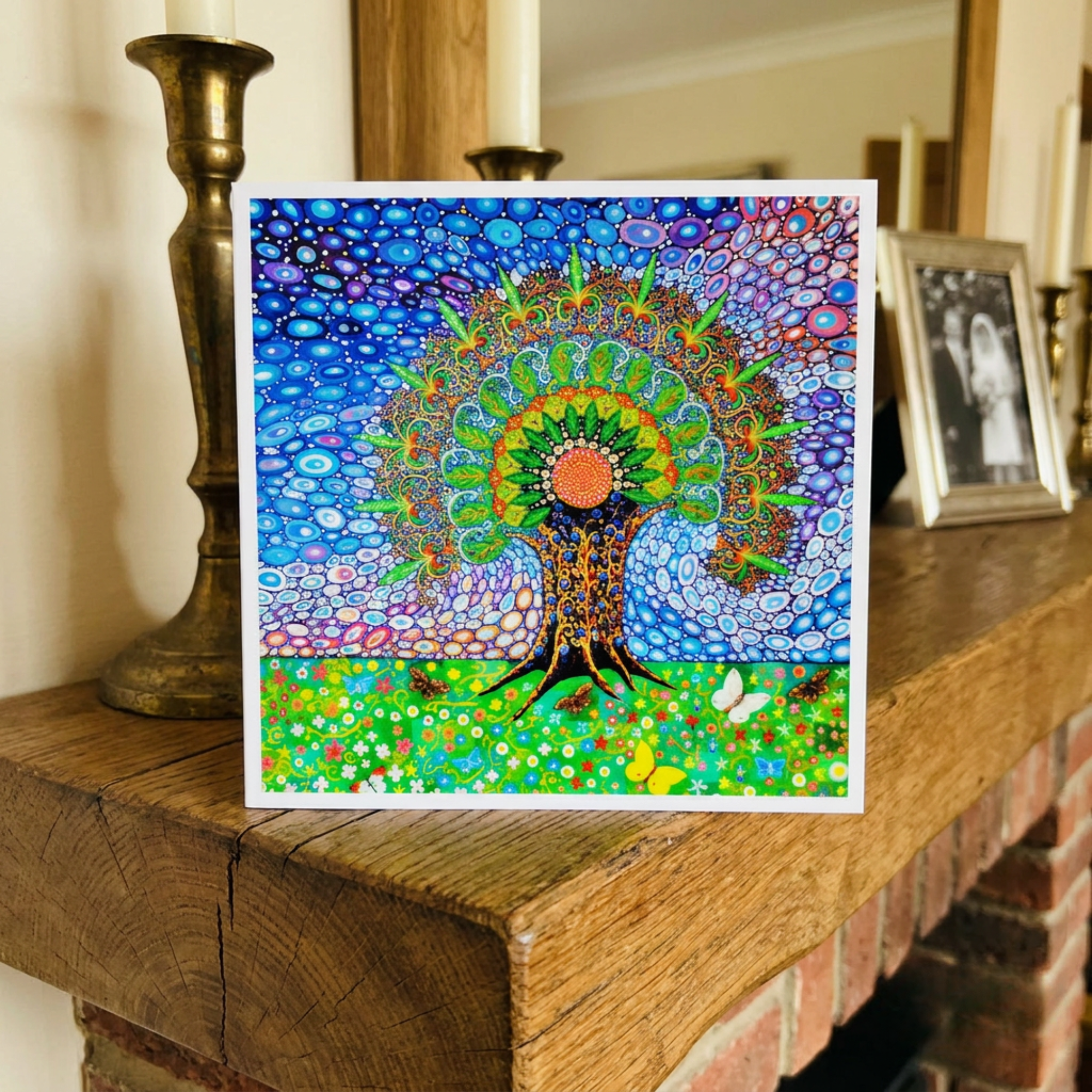 Colourful abstract artwork on a wooden surface with candles and a mirror in the background