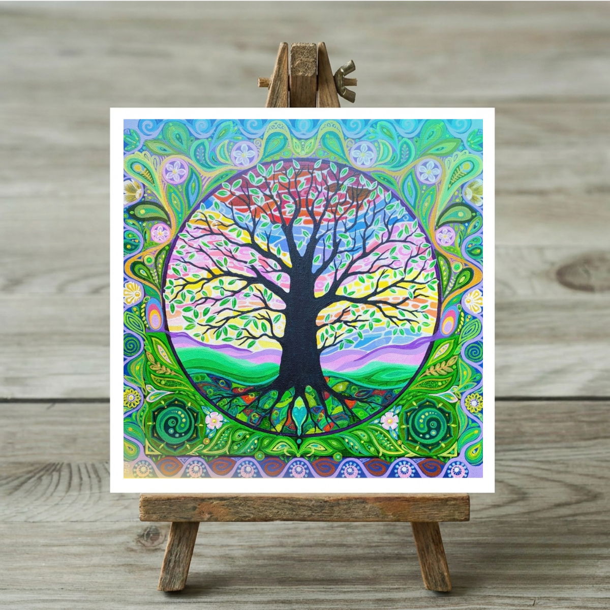Colourful tree of life artwork on a wooden easel against a wooden background