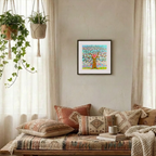 Cozy living room with patterned pillows, a coffee cup, and a framed artwork on the wall.