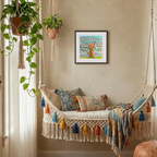 Decorative indoor swing with colourful pillows and a framed artwork on the wall.