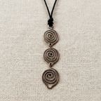 Necklace with spiral pendant on a beige fabric background