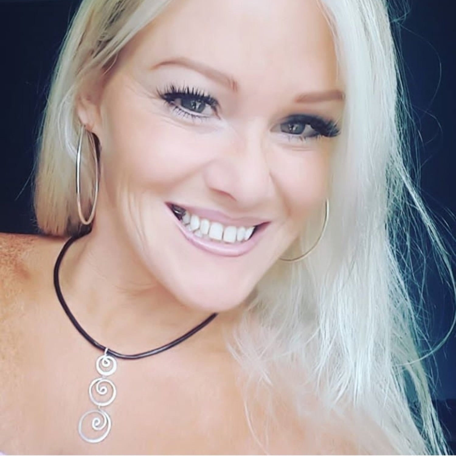 Woman wearing a necklace with a dark background