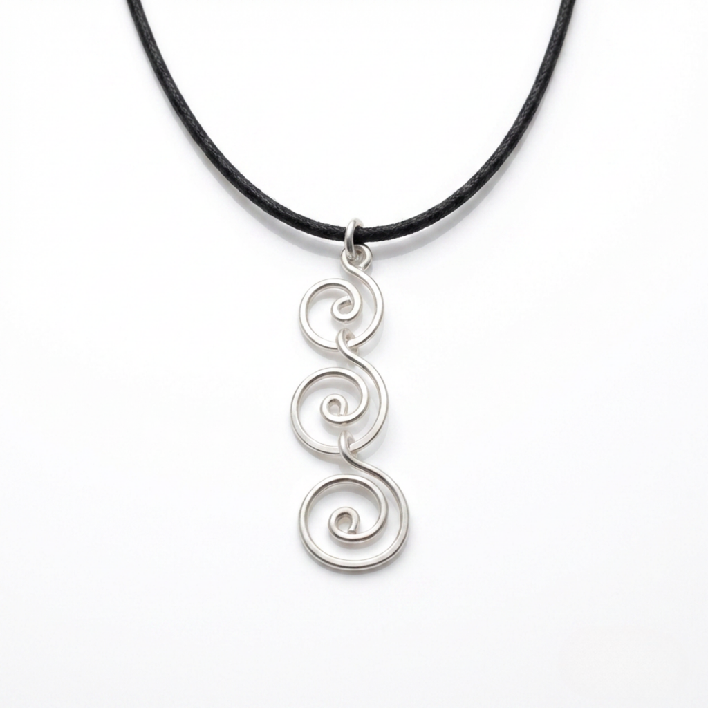 Silver spiral pendant on a black cord against a white background