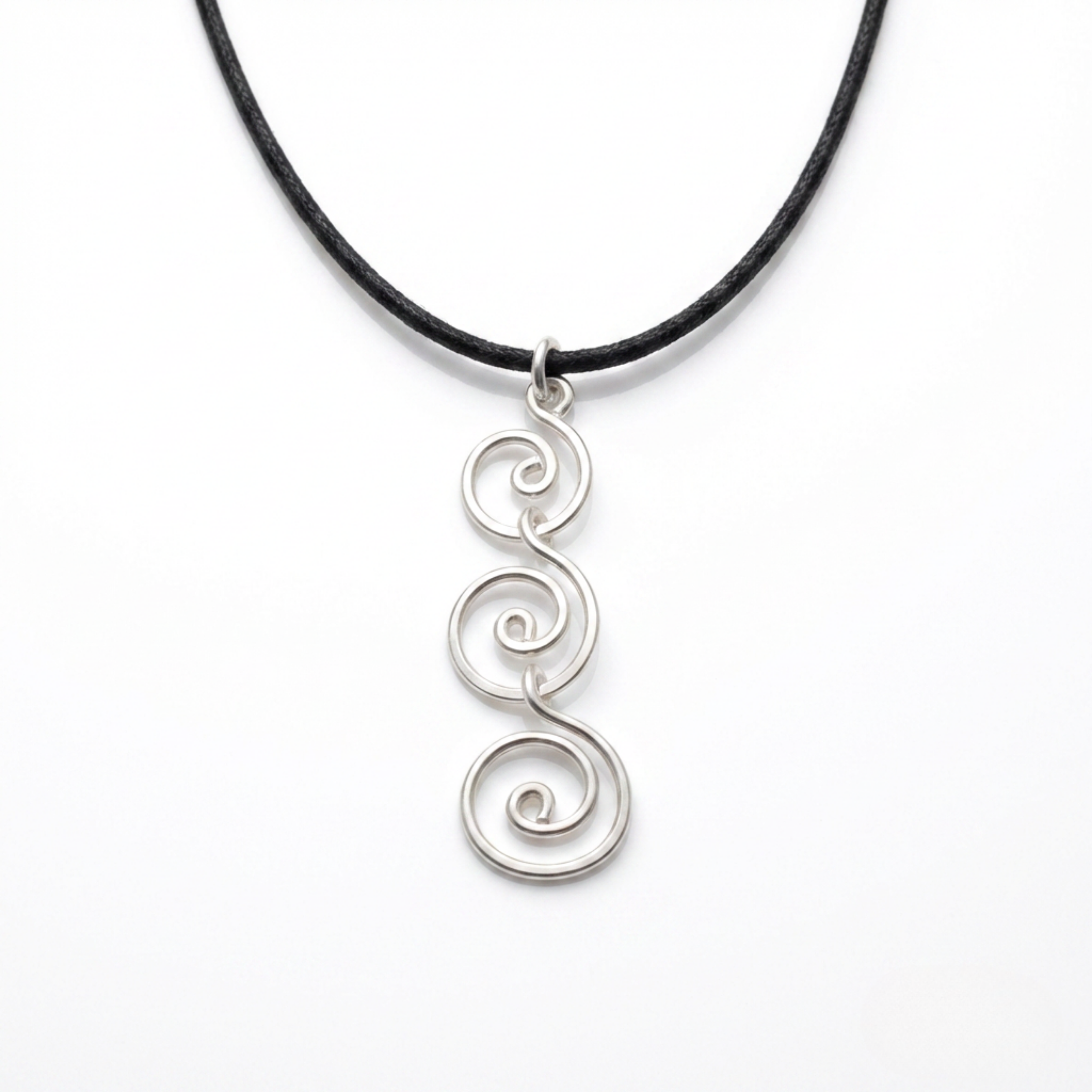 Silver spiral pendant on a black cord against a white background